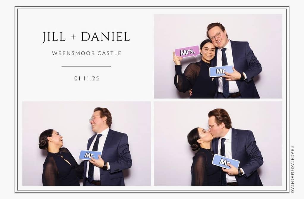 a couple posing for a photo in a wedding photo booth while holding a retro brick phone