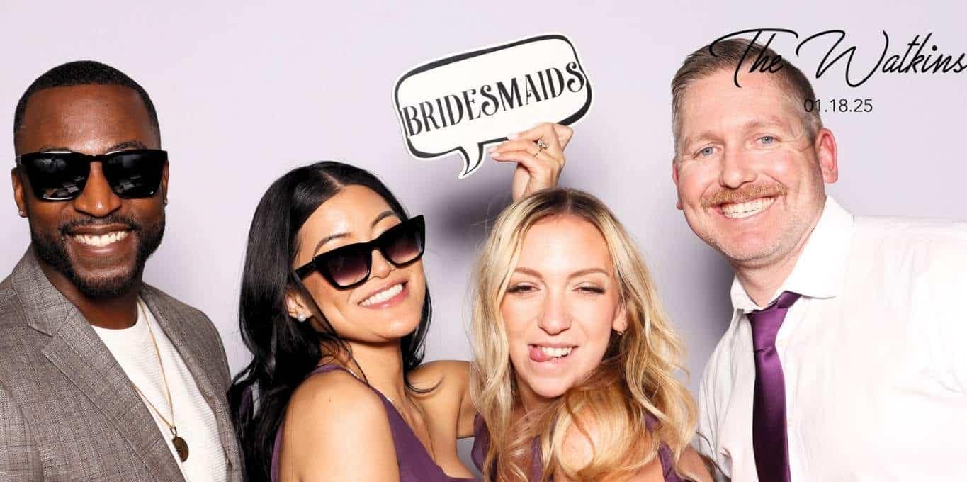 Wedding guests posing with props at The Watkins' photo booth in Beverly Hills, smiling and celebrating.