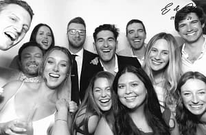 a group of people posing for a photo in a black and white wedding photo booth