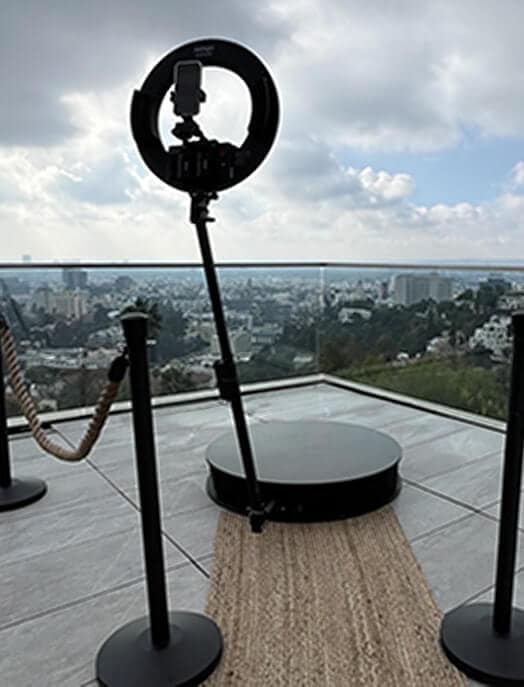 360 photo booth with ring light and platform on a Los Angeles rooftop, surrounded by stanchions and city view