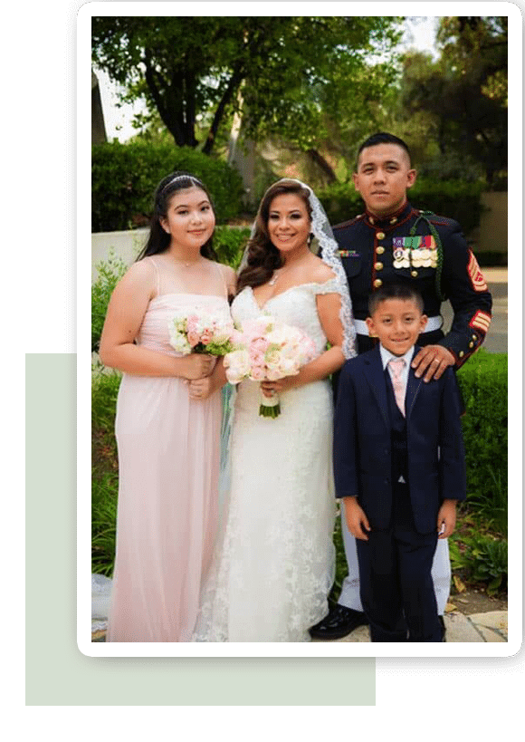 Smiling family in formal wear posing for a wedding portrait.