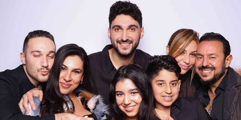 A group of guests, including kids, smiling at the Sasooness Law Group 2024 Holiday Party in Del Mar.