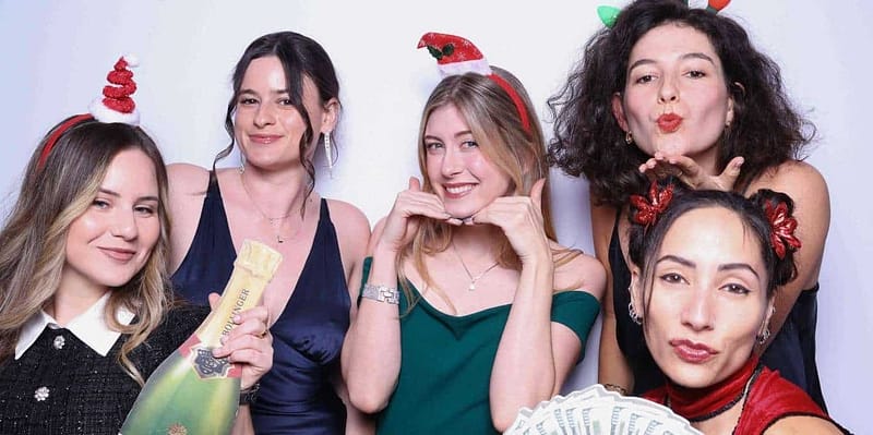 Five women posing with festive props at the Sasooness Law Group photo booth rental in Escondido, smiling.
