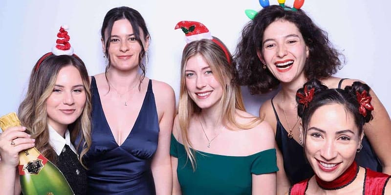 Five ladies posing with festive props and smiles at the Sasooness Law Group photo booth in San Marcos.